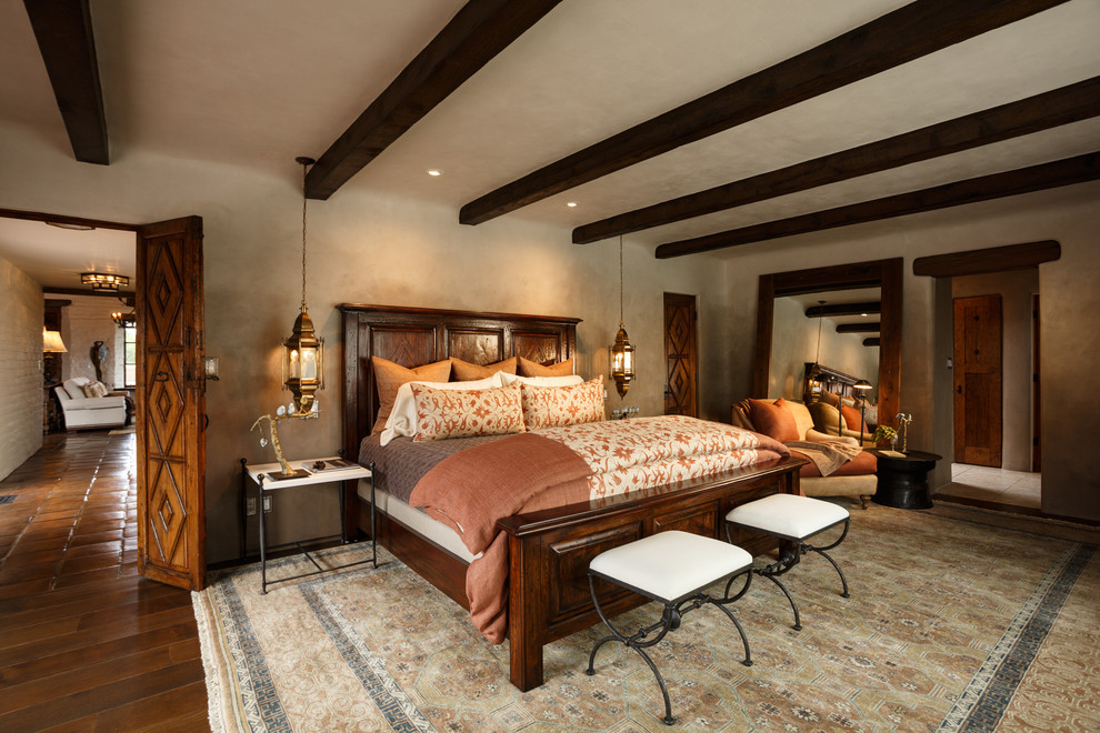 Modelo de dormitorio principal de estilo americano grande con paredes grises y suelo de madera oscura