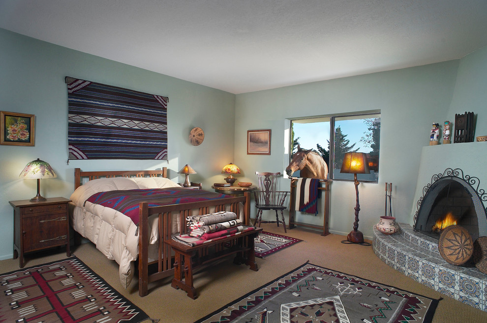 На фото: большая хозяйская спальня в стиле фьюжн с зелеными стенами, ковровым покрытием, угловым камином и фасадом камина из штукатурки