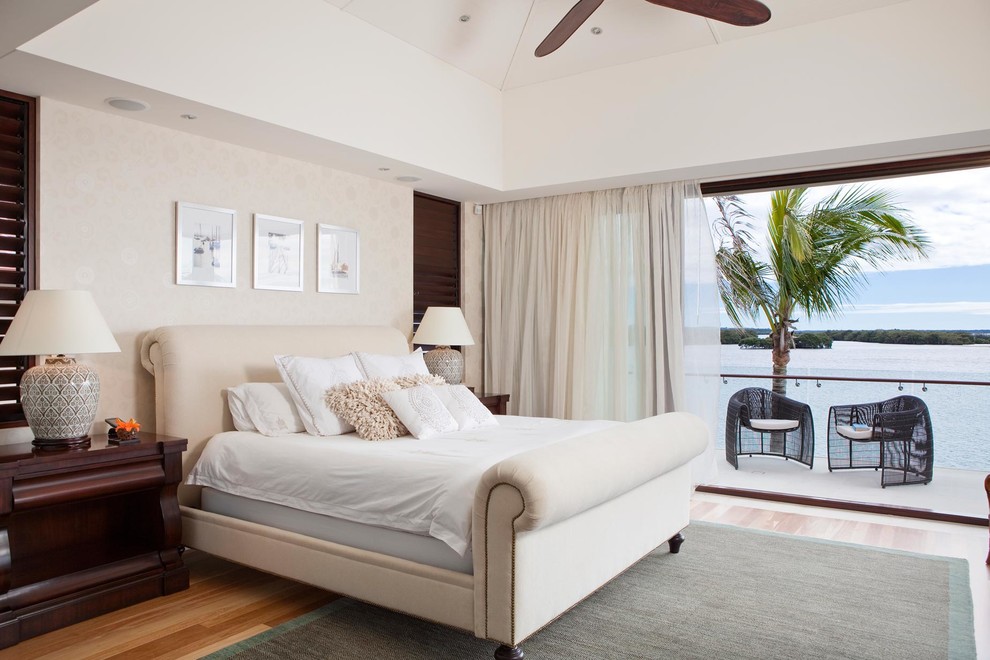 Ejemplo de dormitorio exótico de tamaño medio con paredes beige y suelo de madera en tonos medios