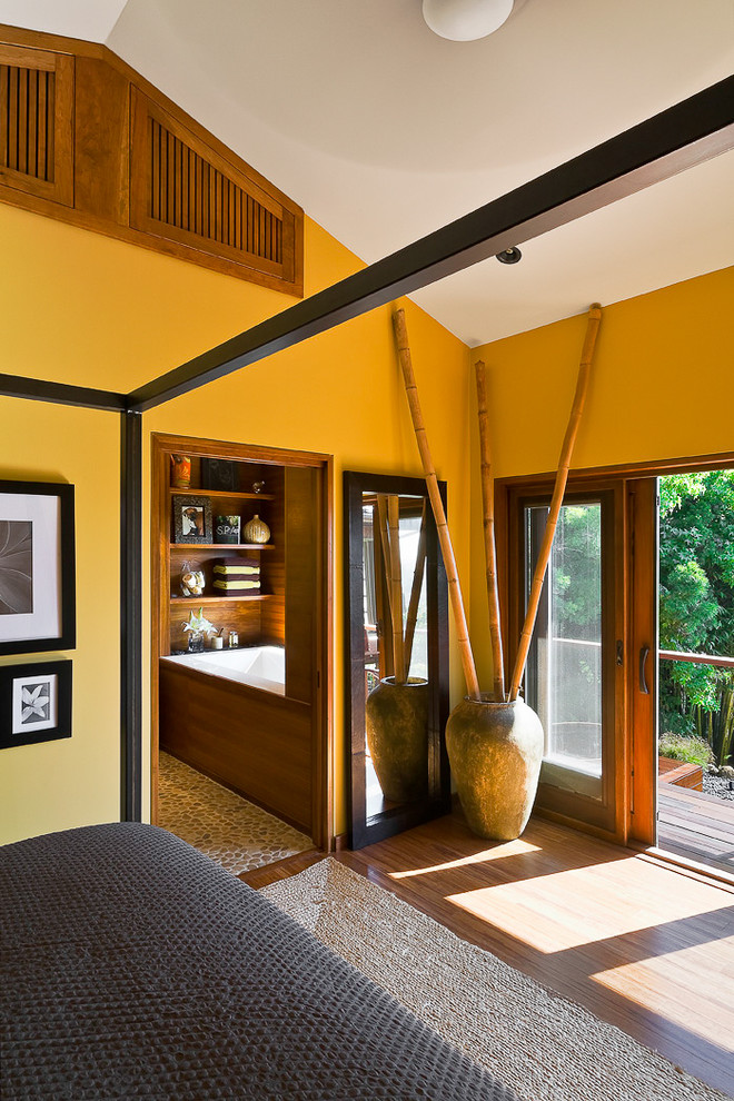 На фото: хозяйская спальня среднего размера в современном стиле с желтыми стенами, паркетным полом среднего тона и коричневым полом без камина с