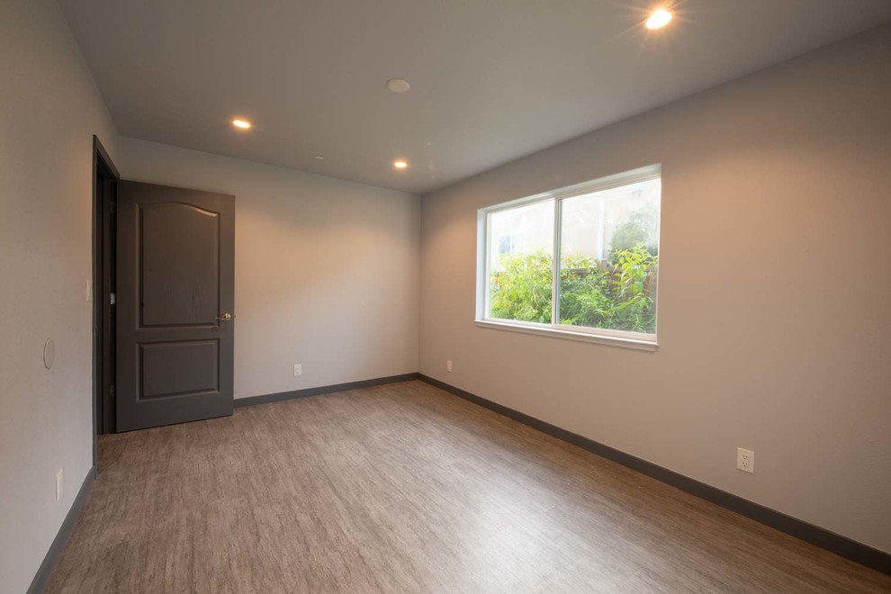 Kleines Rustikales Schlafzimmer ohne Kamin, im Loft-Style mit weißer Wandfarbe, Laminat und grauem Boden in San Francisco