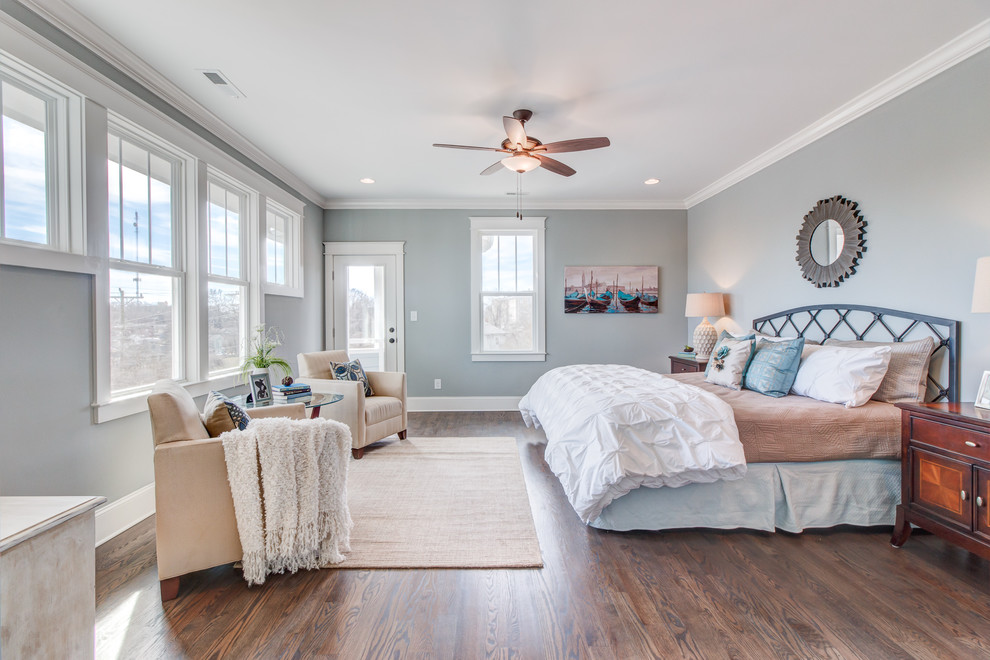 Cette photo montre une grande chambre parentale chic avec un mur gris et parquet foncé.