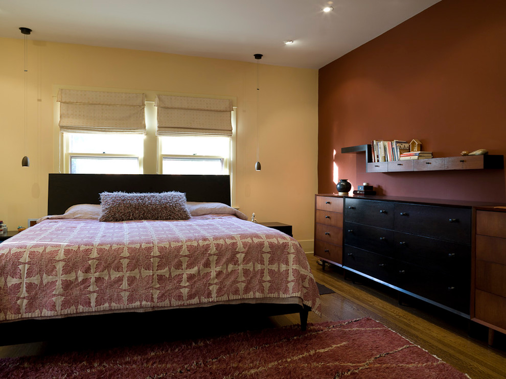 Réalisation d'une chambre parentale minimaliste de taille moyenne avec un mur beige et un sol en bois brun.
