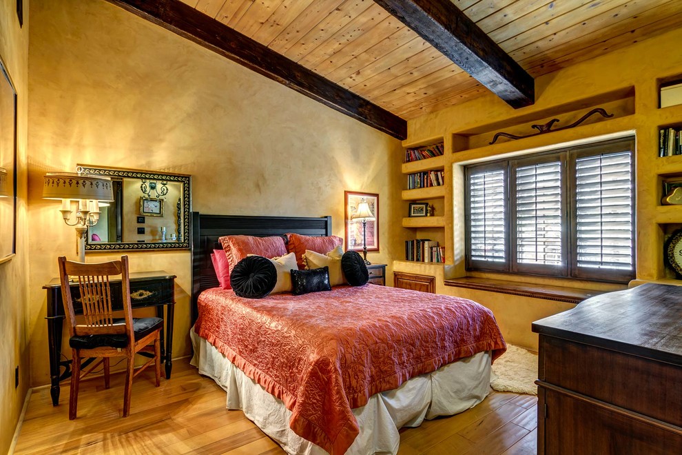 Large guest bedroom in San Diego with yellow walls and medium hardwood flooring.