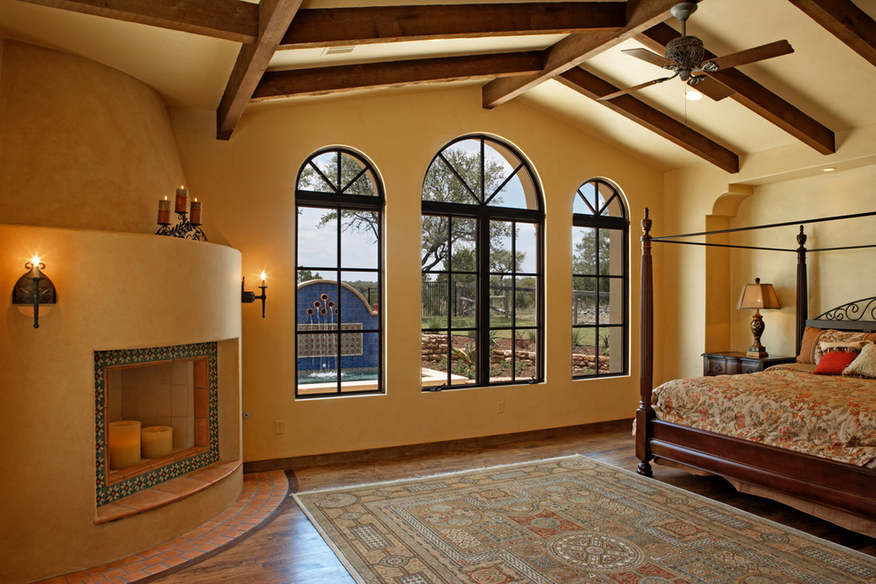 Пример оригинального дизайна: спальня в стиле фьюжн с желтыми стенами и угловым камином