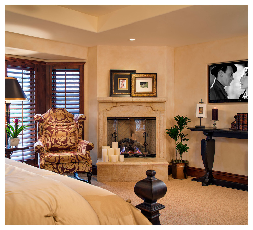 サンディエゴにある広い地中海スタイルのおしゃれな主寝室 (カーペット敷き、コーナー設置型暖炉、漆喰の暖炉まわり、ベージュの壁) のインテリア
