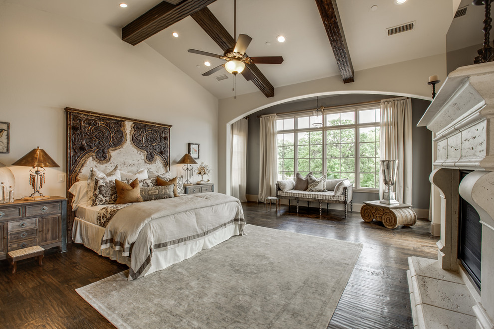 Bedroom - large mediterranean master medium tone wood floor bedroom idea in Dallas with beige walls, a standard fireplace and a stone fireplace