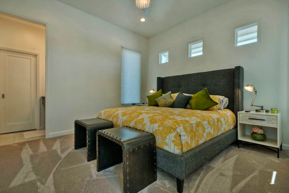 Imagen de dormitorio contemporáneo con paredes grises y moqueta