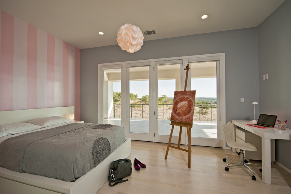 Ejemplo de dormitorio contemporáneo con paredes multicolor, suelo de madera clara y con escritorio