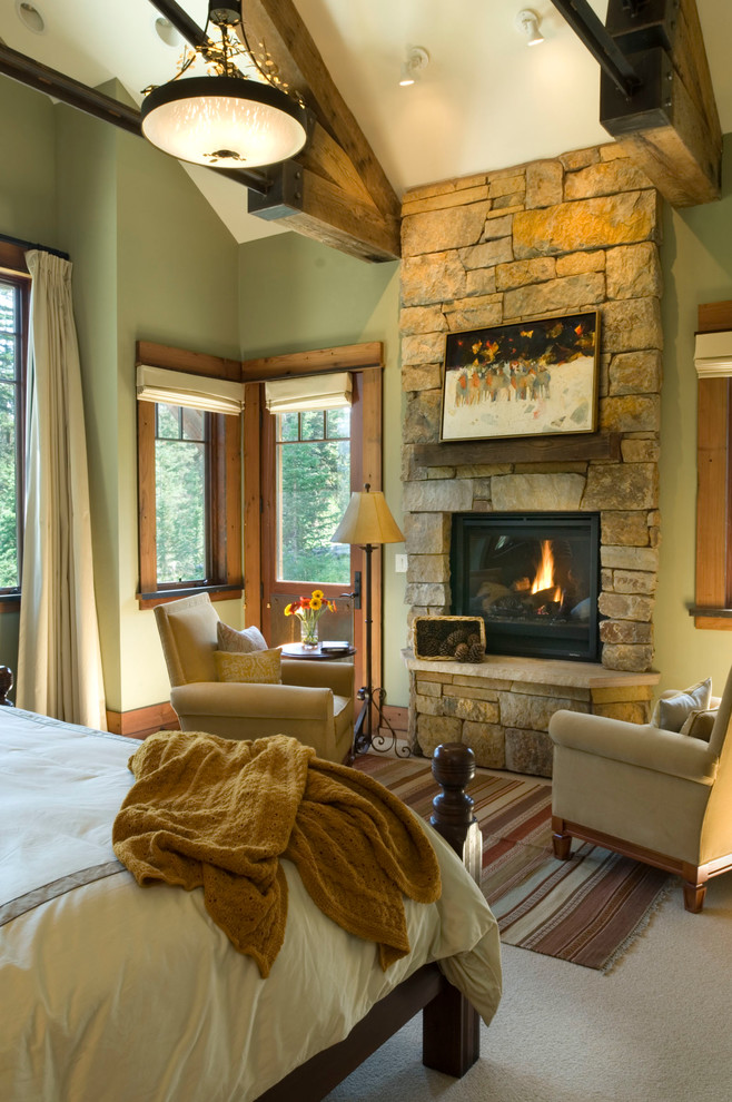 Стильный дизайн: большая хозяйская спальня в современном стиле с зелеными стенами, ковровым покрытием, стандартным камином и фасадом камина из камня - последний тренд