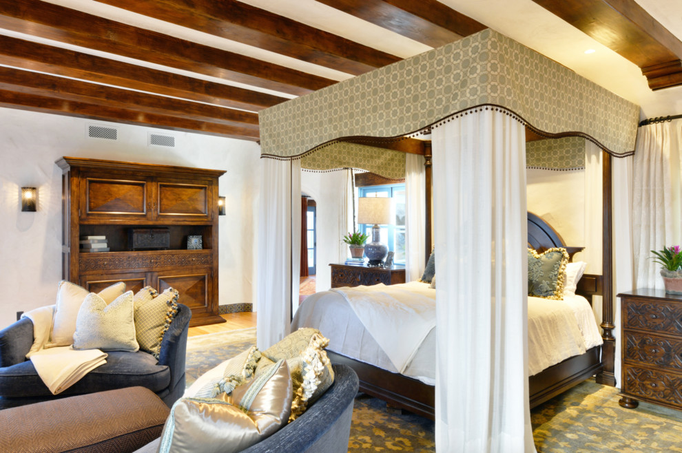 サンディエゴにある巨大な地中海スタイルのおしゃれな主寝室 (白い壁、濃色無垢フローリング、標準型暖炉、漆喰の暖炉まわり、茶色い床) のレイアウト