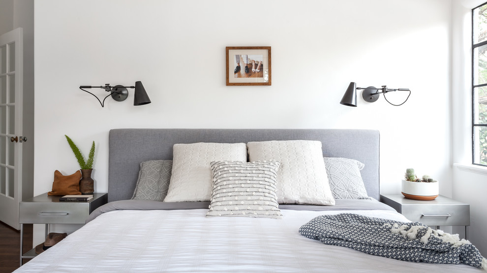 Стильный дизайн: хозяйская спальня с белыми стенами, паркетным полом среднего тона и коричневым полом - последний тренд
