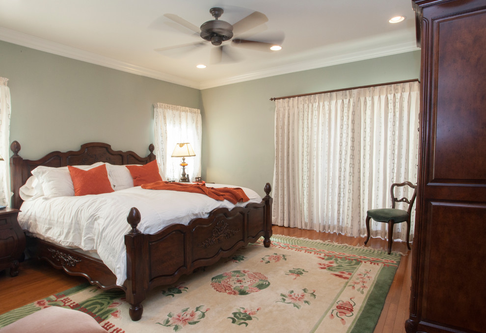 Imagen de dormitorio principal mediterráneo de tamaño medio sin chimenea con paredes verdes y suelo de madera en tonos medios