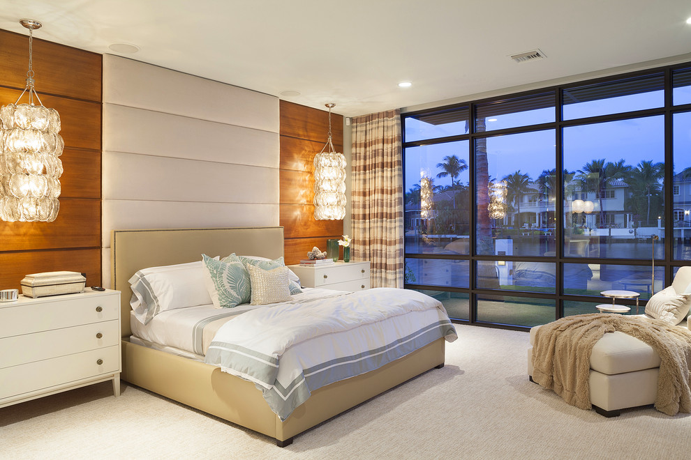 This is an example of a contemporary bedroom in Miami with beige walls and carpet.
