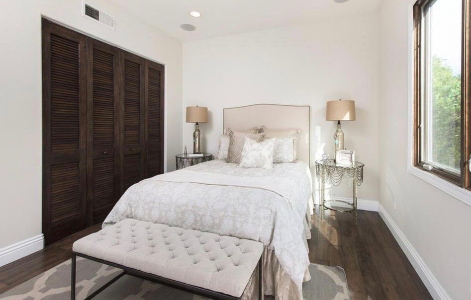 Mittelgroßes Klassisches Gästezimmer mit weißer Wandfarbe, dunklem Holzboden und braunem Boden in Los Angeles
