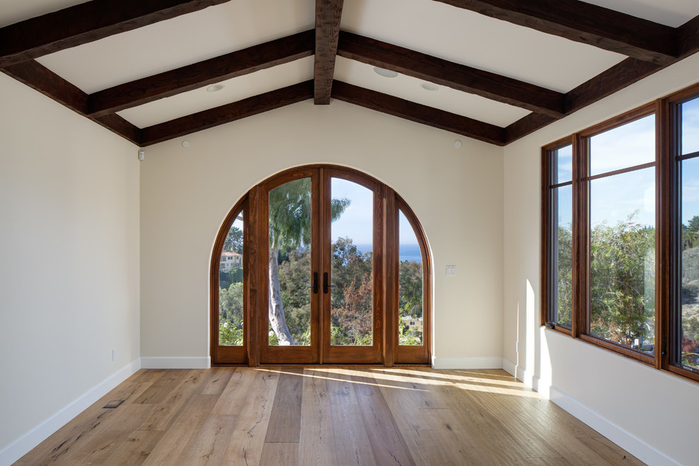 Großes Mediterranes Hauptschlafzimmer ohne Kamin mit beiger Wandfarbe, braunem Holzboden und braunem Boden in San Diego