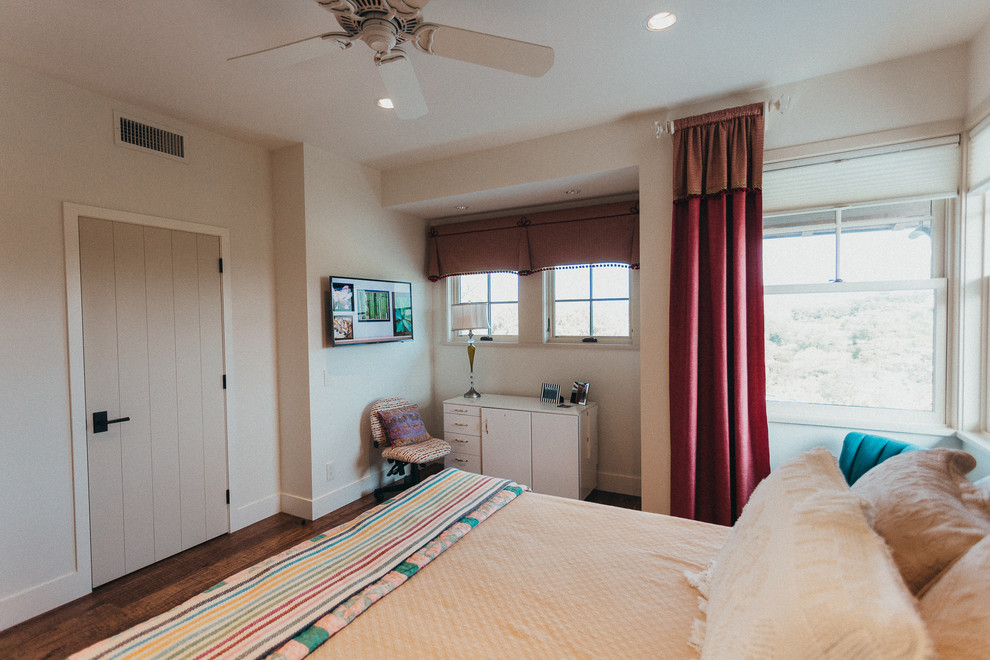 Exemple d'une petite chambre d'amis sud-ouest américain avec un mur beige, un sol en bois brun, aucune cheminée et un sol marron.