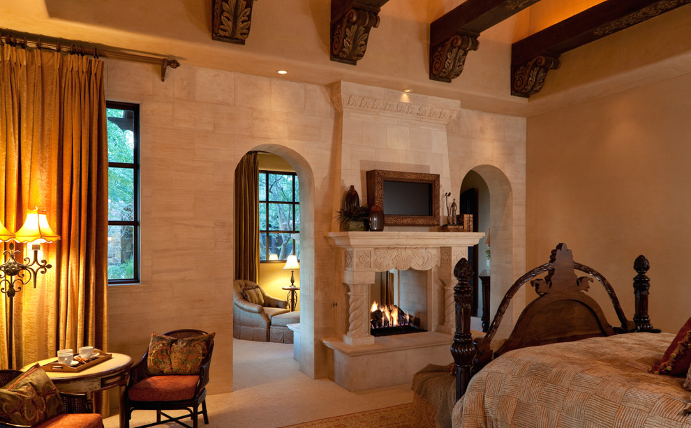 На фото: огромная хозяйская спальня в классическом стиле с коричневыми стенами, полом из терракотовой плитки, двусторонним камином и фасадом камина из камня