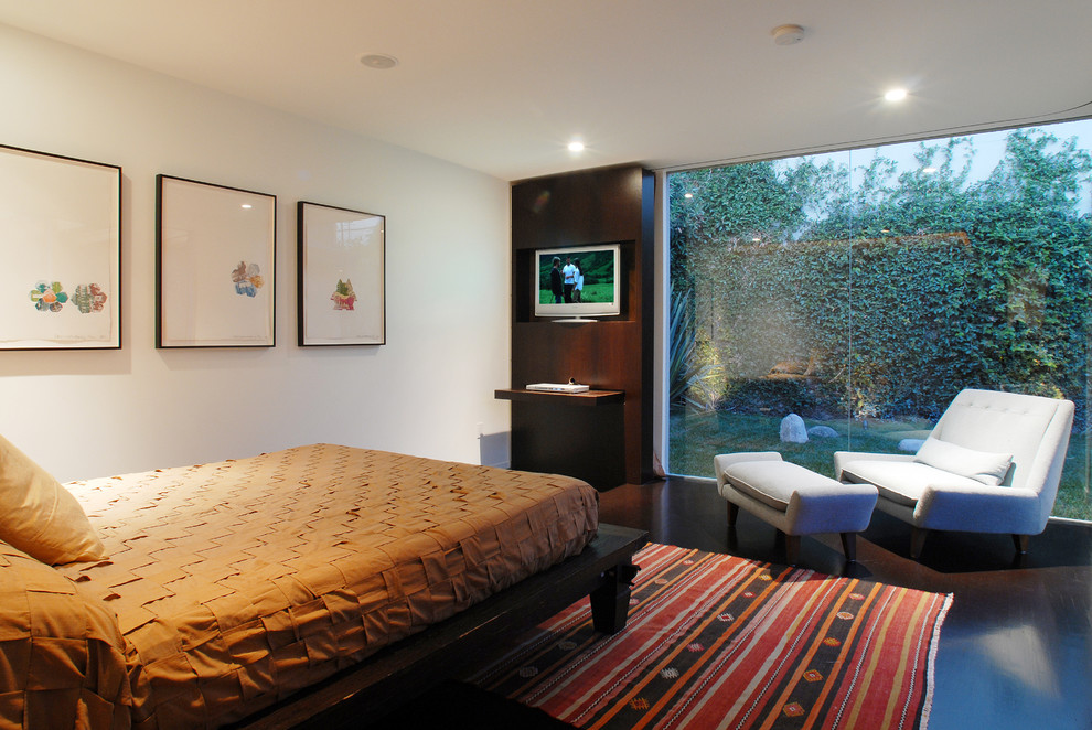 Modelo de dormitorio minimalista con paredes blancas y suelo de madera oscura