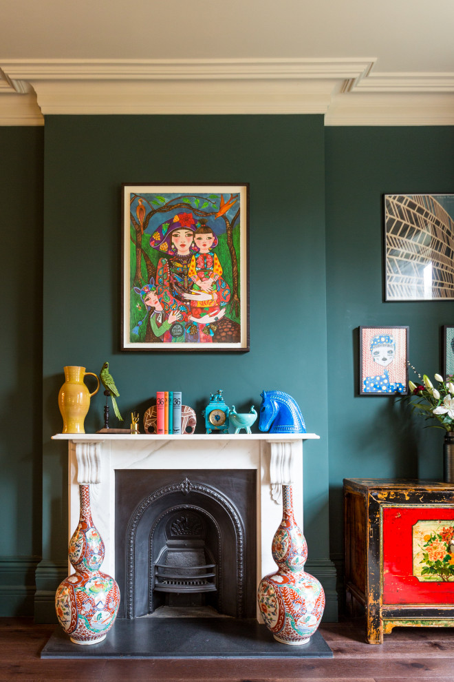 ロンドンにある高級な広いヴィクトリアン調のおしゃれなリビング (緑の壁、濃色無垢フローリング、標準型暖炉、石材の暖炉まわり、茶色い床) の写真