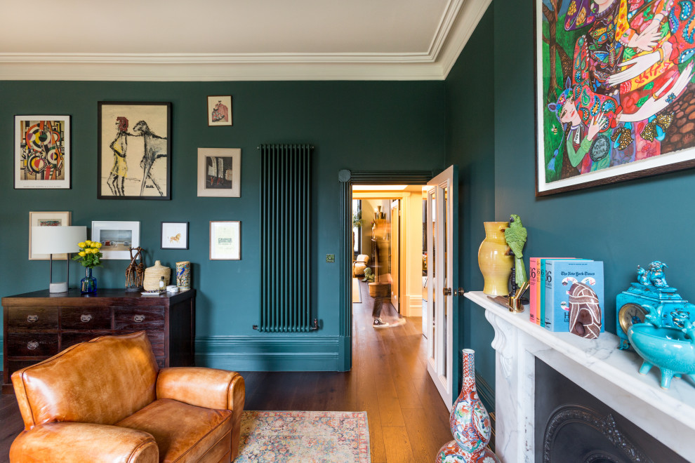 Großes Klassisches Hauptschlafzimmer mit grüner Wandfarbe, dunklem Holzboden, Kamin, Kaminumrandung aus Stein und braunem Boden in London