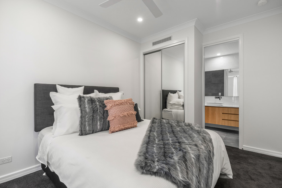 Ejemplo de habitación de invitados actual de tamaño medio con paredes blancas, moqueta y suelo gris