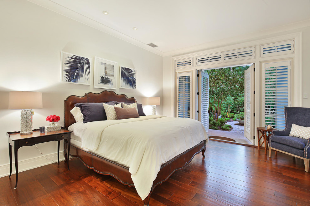 Modelo de dormitorio principal exótico grande con paredes verdes y suelo de madera en tonos medios