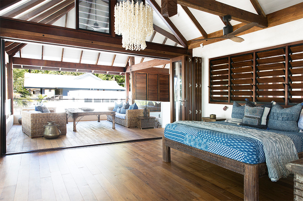 Idee per una camera da letto tropicale con pareti bianche, parquet scuro e pavimento marrone
