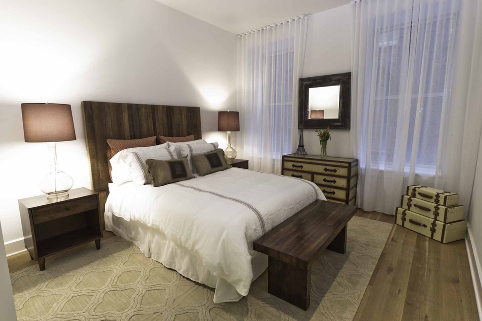 Imagen de habitación de invitados industrial de tamaño medio con paredes blancas, suelo de madera clara y suelo beige