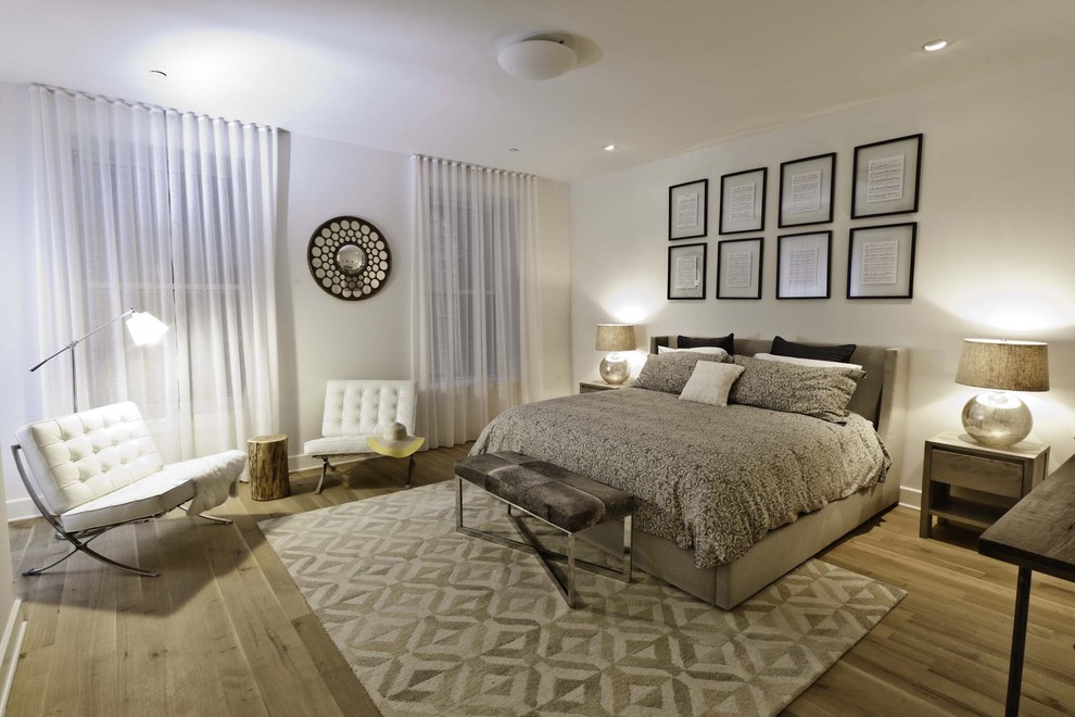 Immagine di una grande camera da letto stile loft industriale con pareti bianche e parquet chiaro