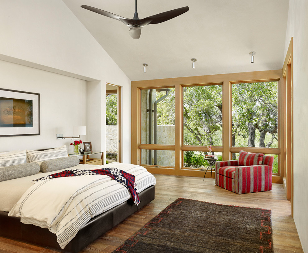 Großes Country Hauptschlafzimmer ohne Kamin mit beiger Wandfarbe, braunem Holzboden und gewölbter Decke in Austin