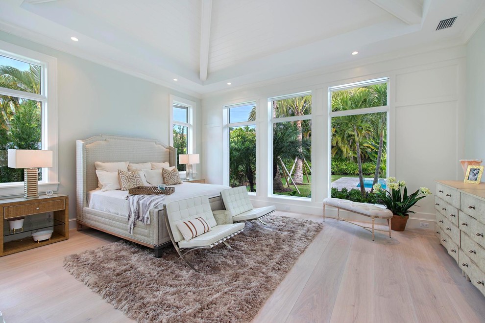 Inspiration for a coastal master light wood floor bedroom remodel in Miami with white walls