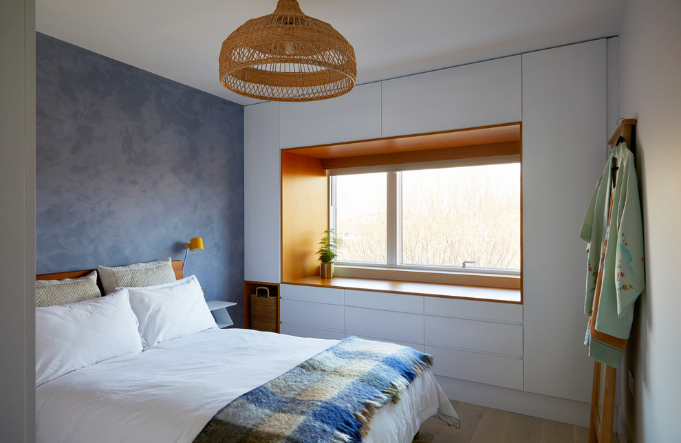 Exemple d'une petite chambre parentale tendance avec un mur bleu, parquet clair, aucune cheminée et un sol gris.