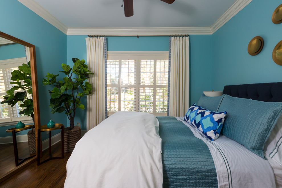 Idée de décoration pour une chambre d'amis tradition avec un mur bleu, parquet foncé et un sol marron.
