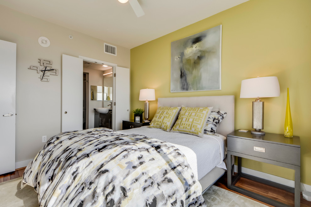 Small traditional master bedroom in Austin with yellow walls and light hardwood flooring.