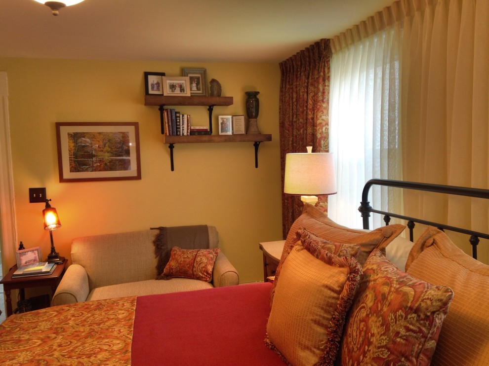 Ejemplo de dormitorio principal de estilo de casa de campo de tamaño medio sin chimenea con paredes amarillas y suelo de madera clara