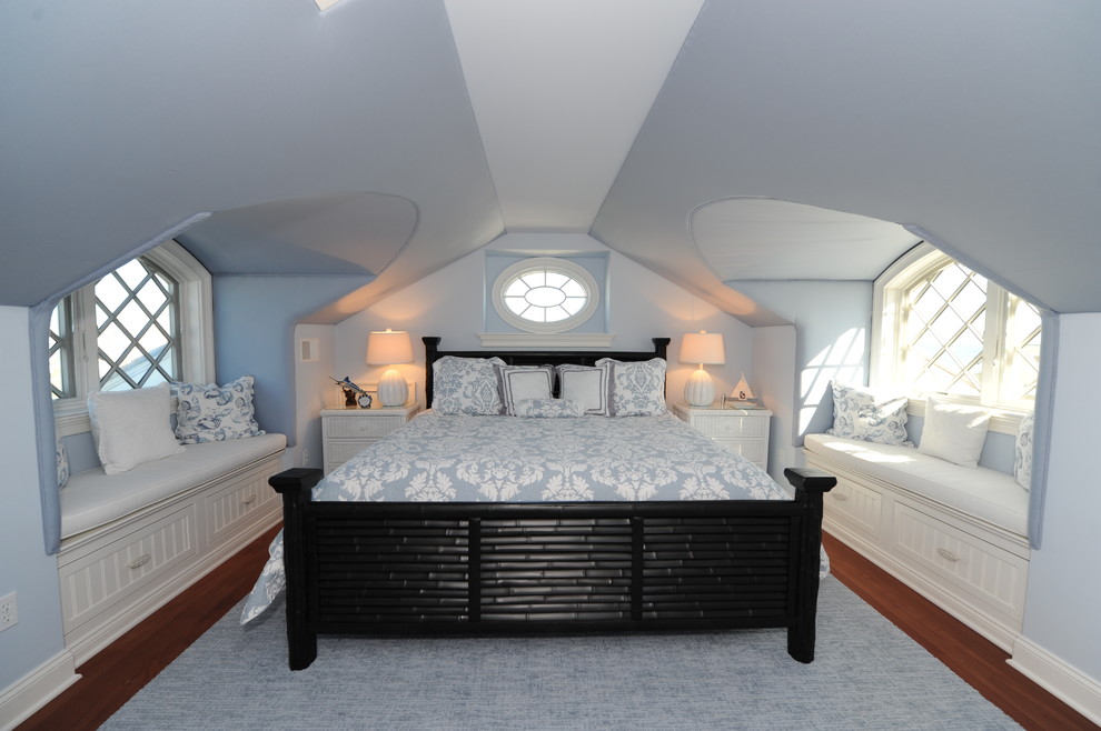 Exemple d'une grande chambre parentale chic avec un mur bleu, parquet foncé, aucune cheminée et un sol marron.