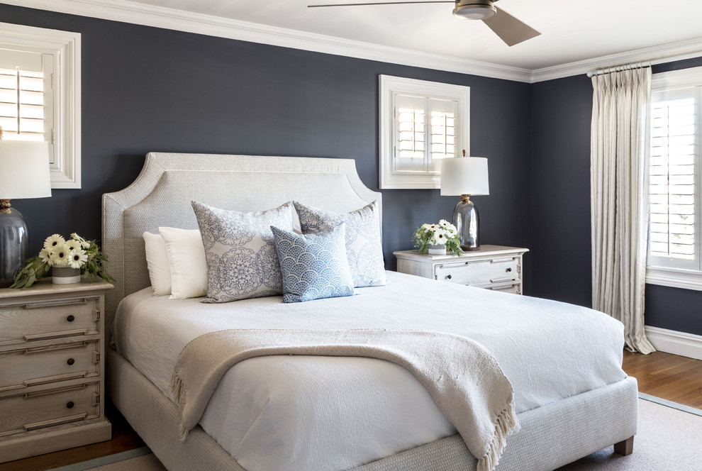 Modelo de dormitorio principal costero con paredes negras y suelo de madera en tonos medios