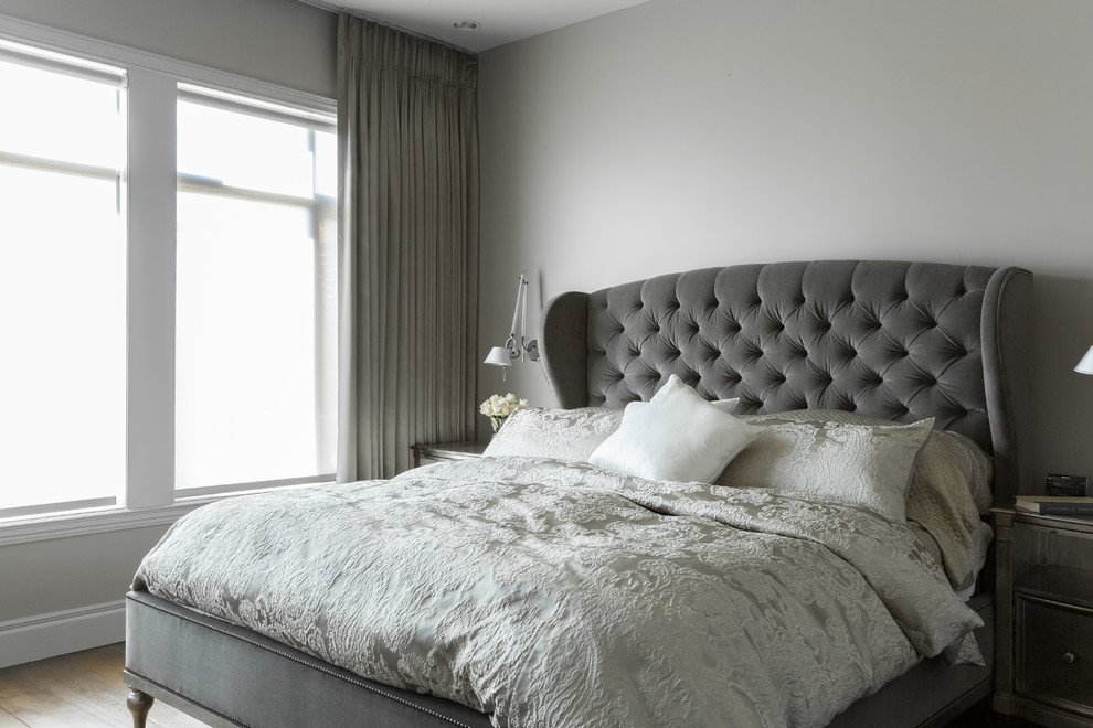 На фото: большая хозяйская спальня в стиле неоклассика (современная классика) с серыми стенами, паркетным полом среднего тона и коричневым полом без камина