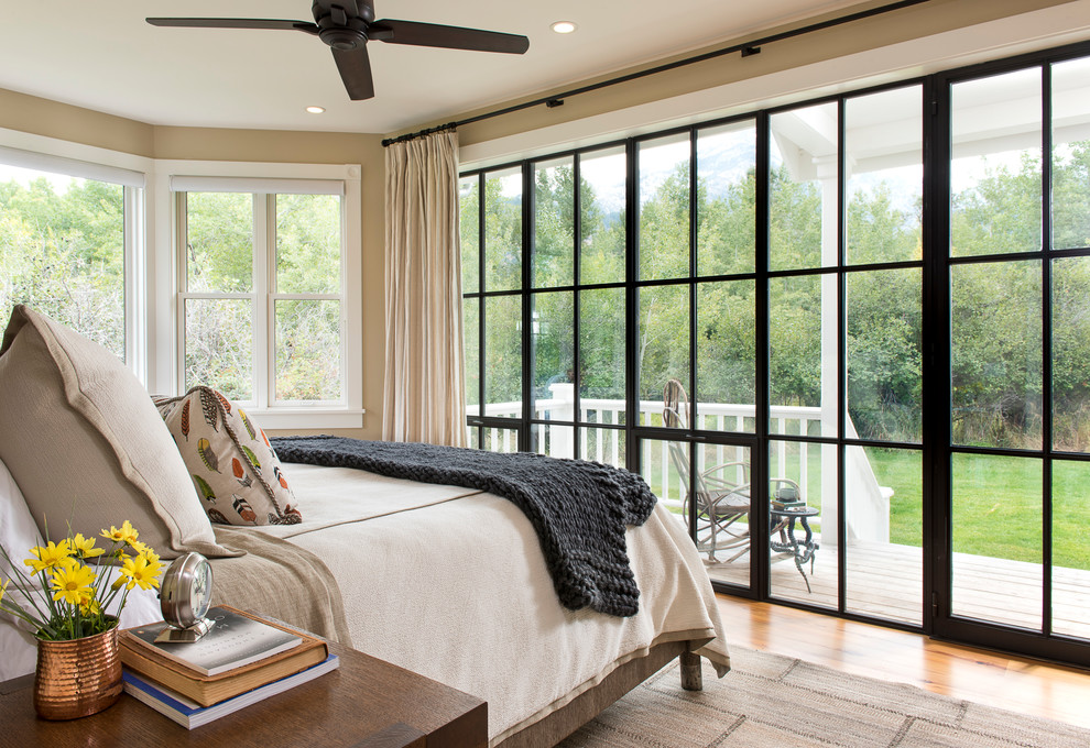 This is an example of a medium sized farmhouse master bedroom in Other with beige walls and light hardwood flooring.