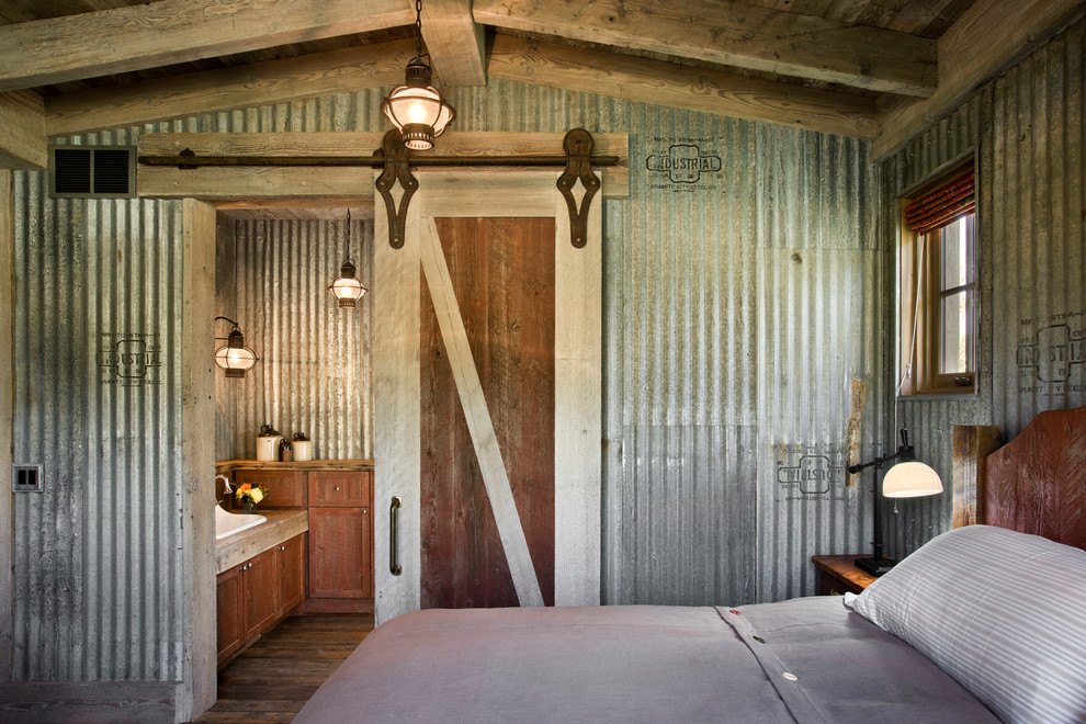 Diseño de dormitorio campestre con paredes grises y suelo de madera oscura