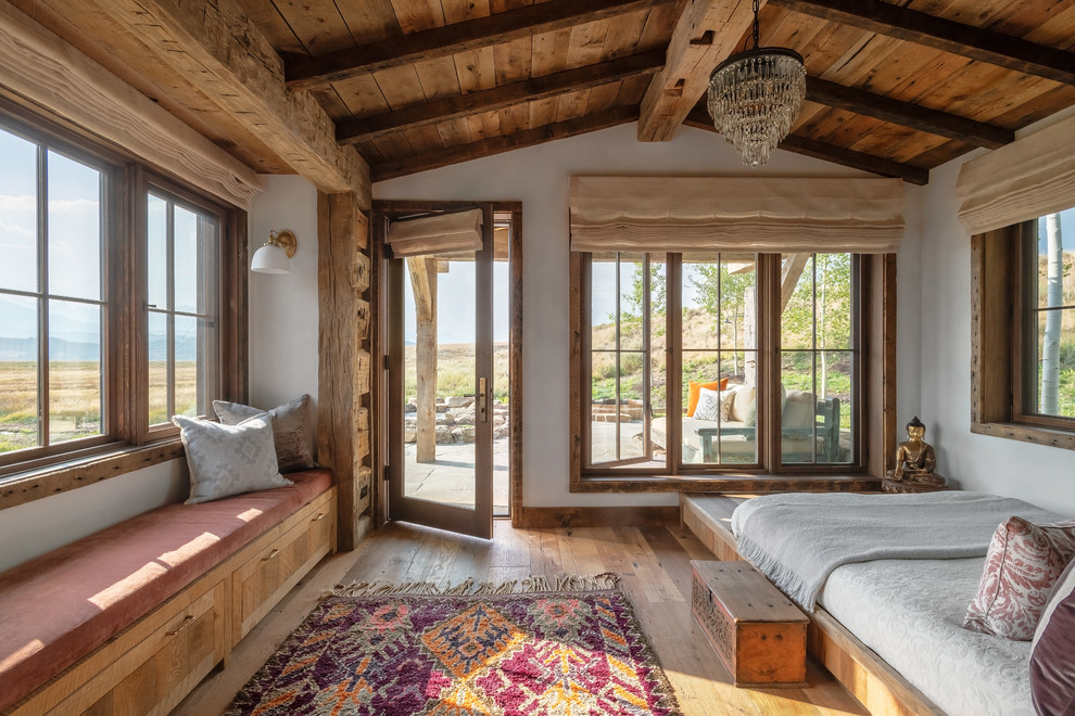 Rustikales Hauptschlafzimmer ohne Kamin mit weißer Wandfarbe und braunem Holzboden in Sonstige