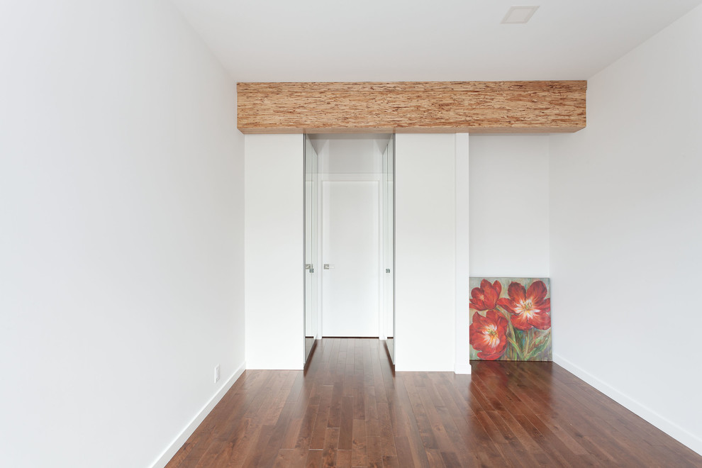 Idéer för ett mellanstort modernt huvudsovrum, med vita väggar, mellanmörkt trägolv och brunt golv