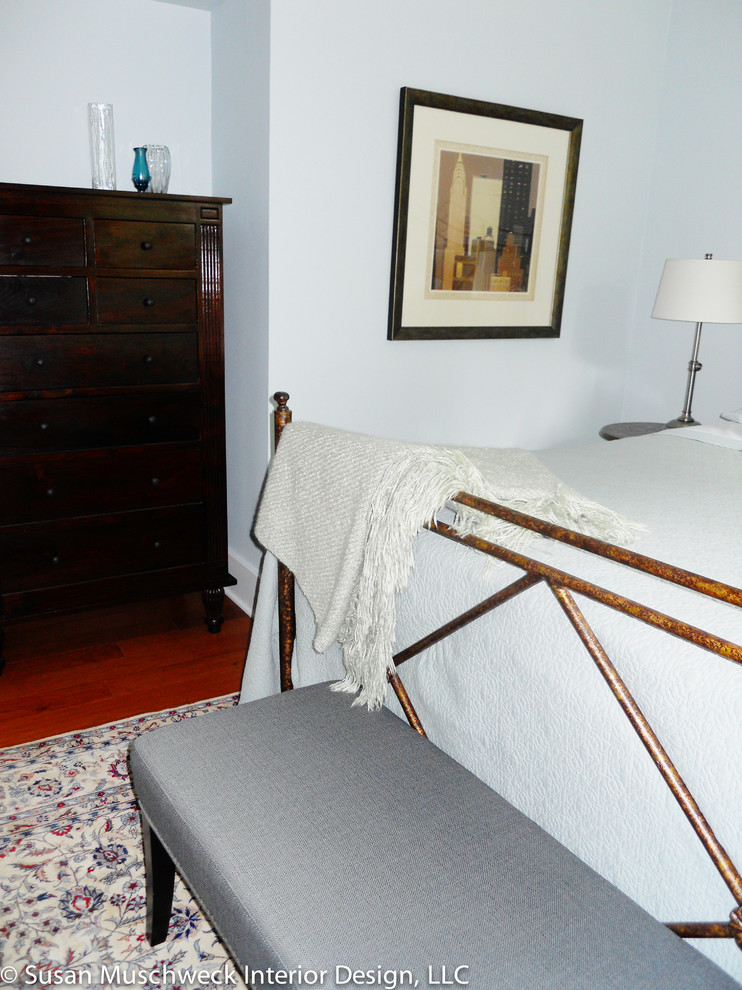 Diseño de dormitorio principal clásico pequeño sin chimenea con paredes azules y suelo de madera oscura