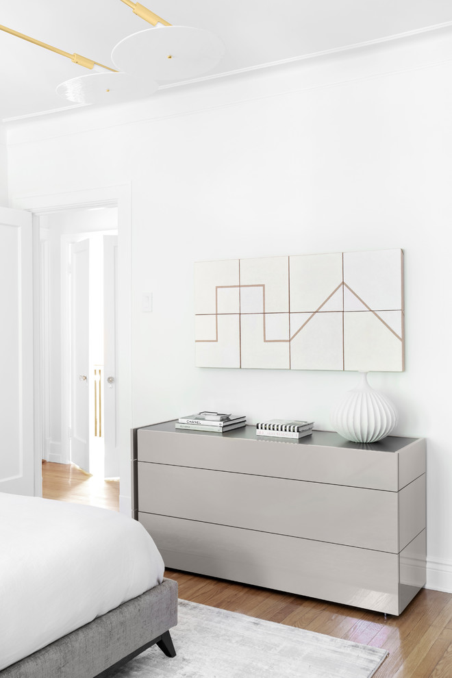 Inspiration pour une chambre parentale design de taille moyenne avec un mur blanc, un sol en bois brun et un sol marron.