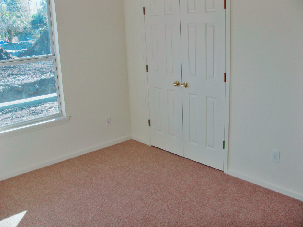 Medium sized classic guest bedroom in Jacksonville with white walls, carpet, no fireplace and beige floors.