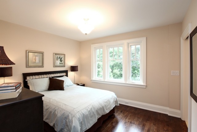 Aménagement d'une chambre d'amis classique de taille moyenne avec un mur beige, parquet foncé, aucune cheminée et un sol marron.
