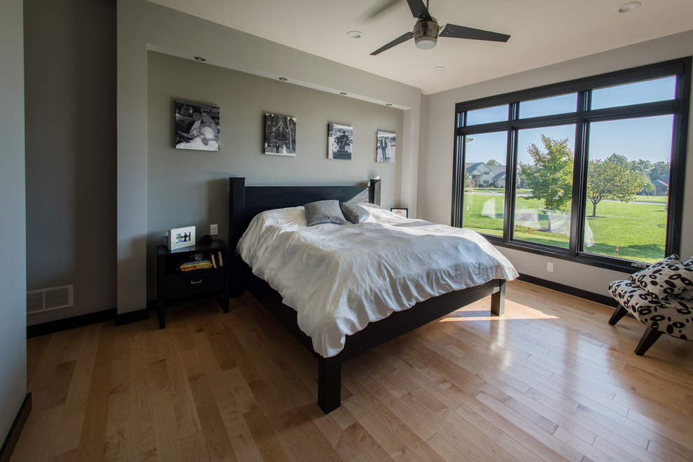 Example of a mid-sized trendy master light wood floor and brown floor bedroom design in Other with gray walls and no fireplace