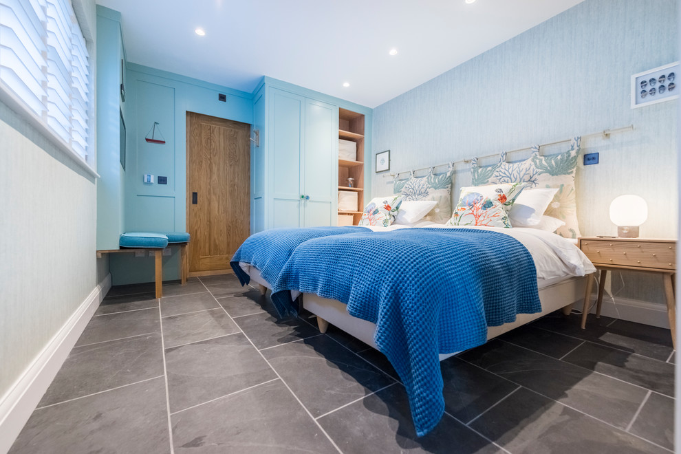 Maritimes Gästezimmer mit blauer Wandfarbe und grauem Boden in Cornwall