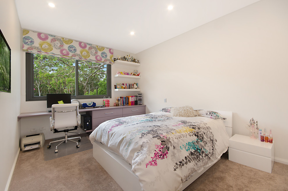 Immagine di una camera da letto design con pareti bianche, moquette e angolo studio